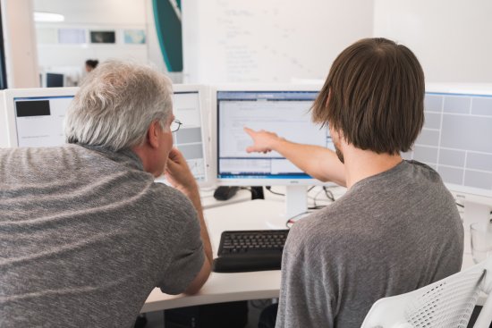 Two men looking at a computer.